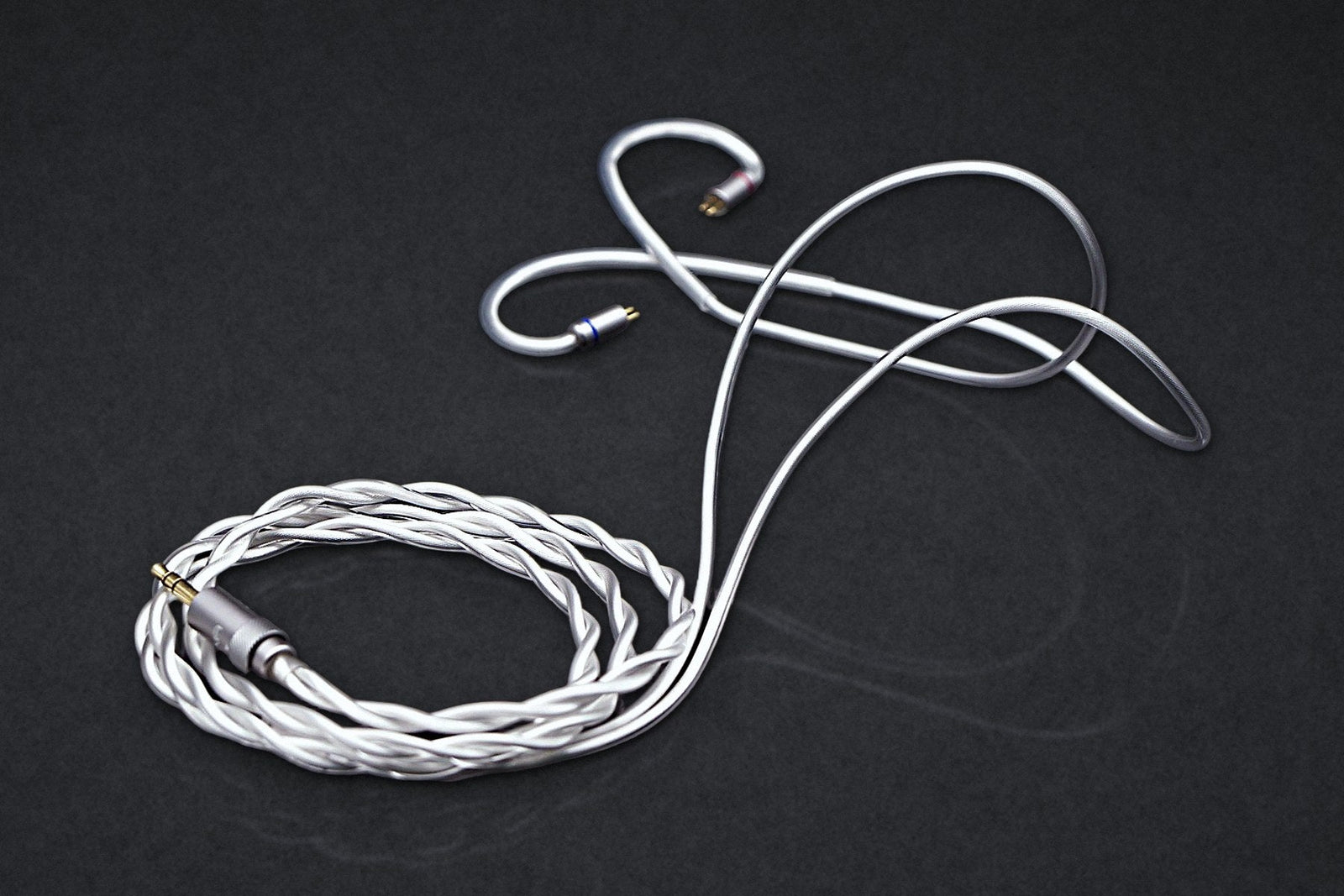 Ethos Ultra modular IEM cable with 3.5 mm plug, coiled on a dark studio backdrop