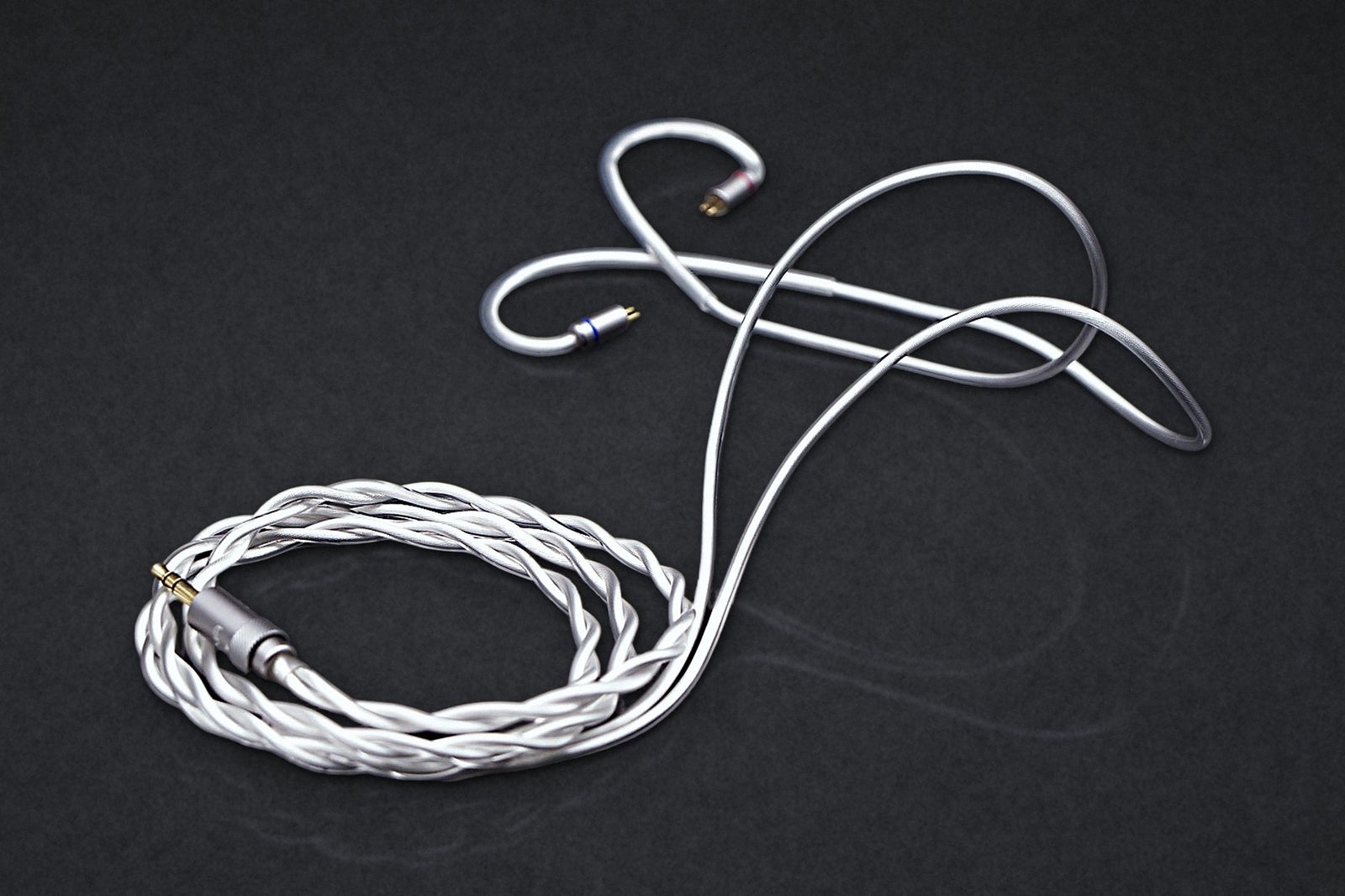 Ethos Ultra coaxial IEM cable with 3.5 mm plug, coiled on a dark studio backdrop