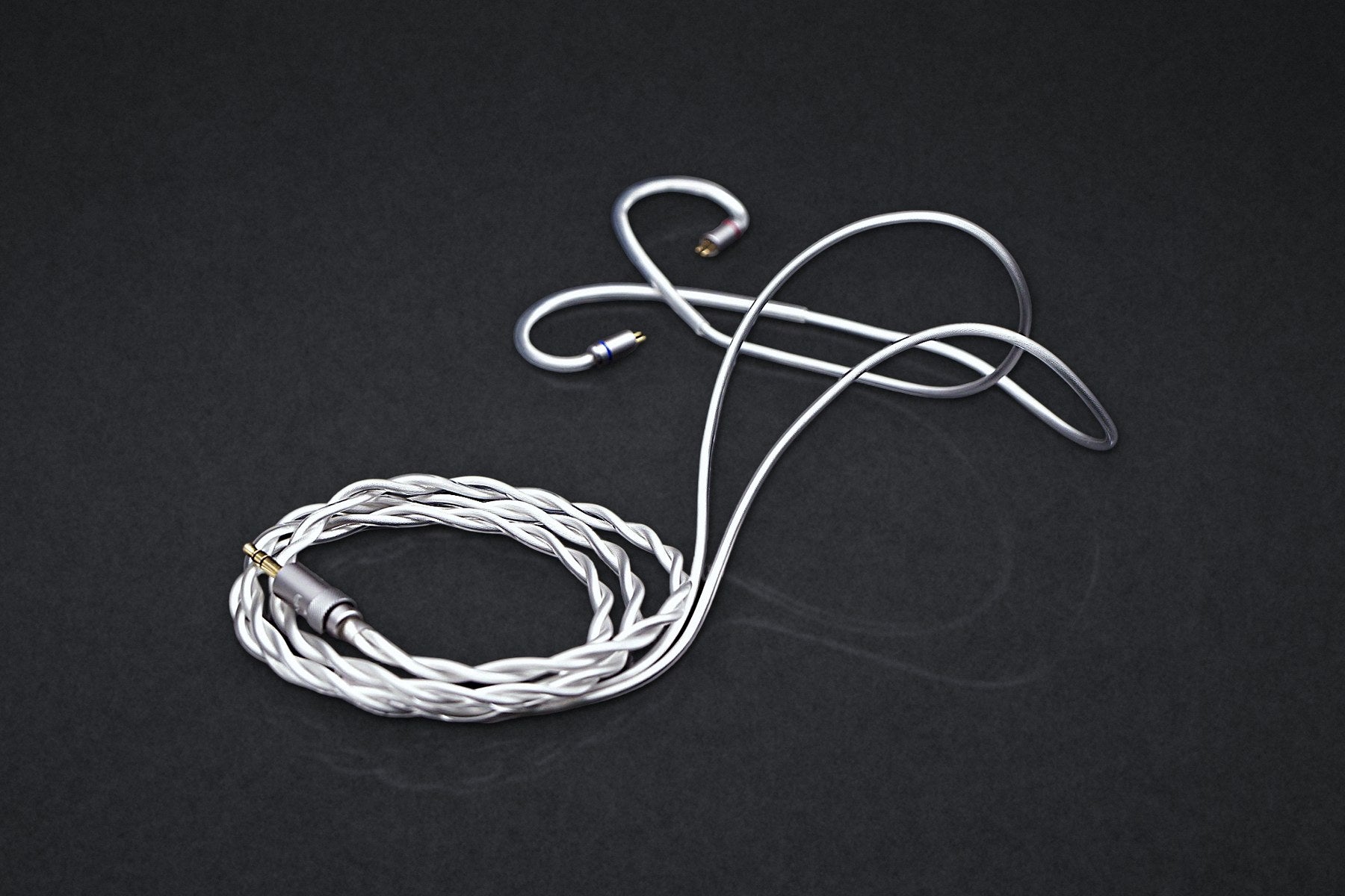 Ethos Ultra silver coaxial IEM cable on a dark studio backdrop